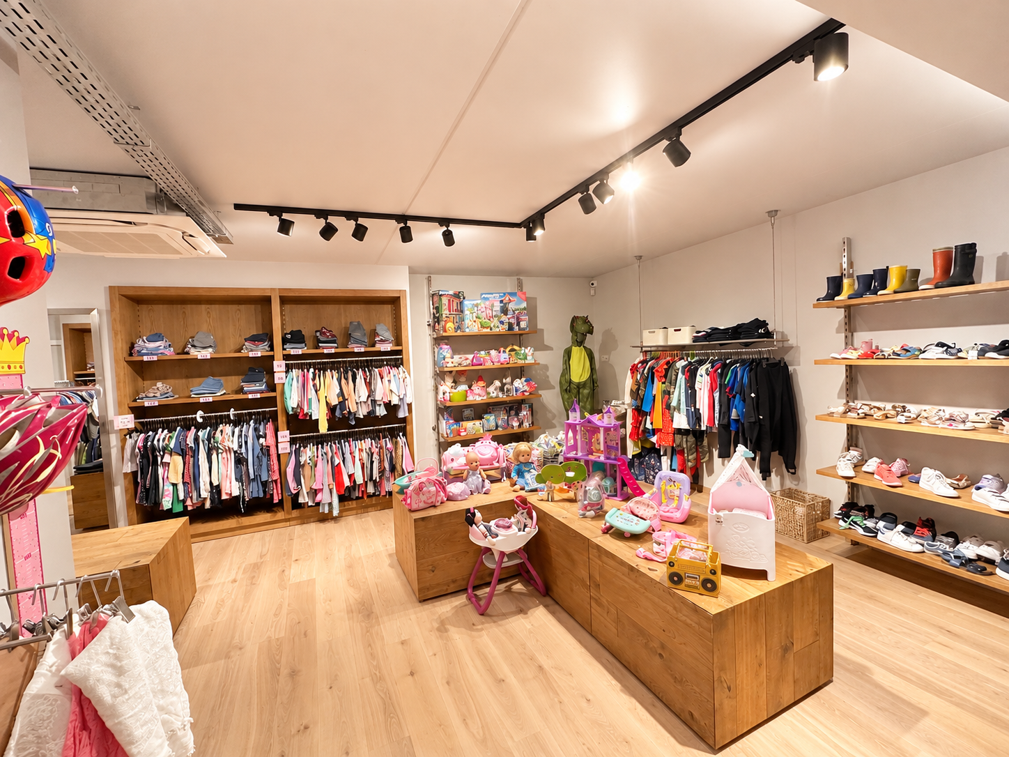 Warm ingerichte winkel met houten rekken vol kinderkleding